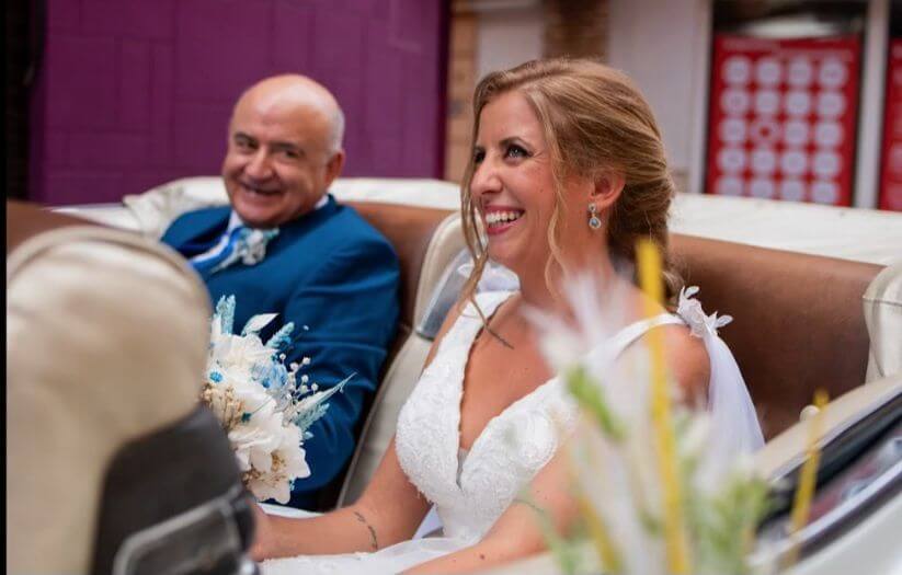 Novia y su padre sonrien en coche de boda